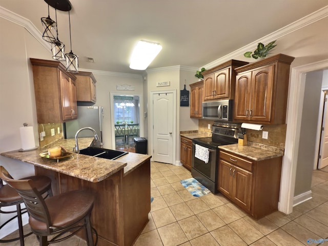 kitchen with tasteful backsplash, light tile patterned floors, appliances with stainless steel finishes, a sink, and a kitchen breakfast bar