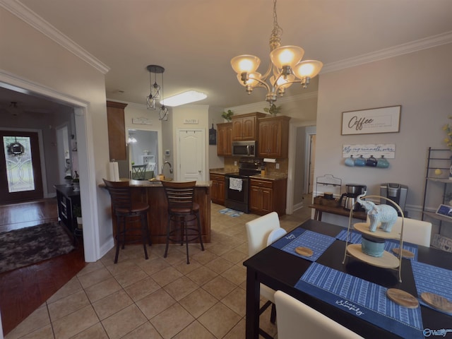 dining space with ornamental molding, light tile patterned floors, a chandelier, and baseboards
