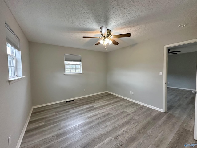 spare room featuring ceiling fan, a textured ceiling, and hardwood / wood-style flooring