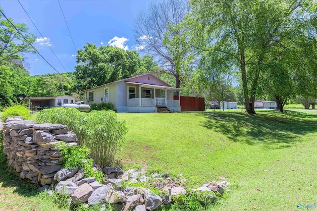 view of yard featuring covered porch and fence