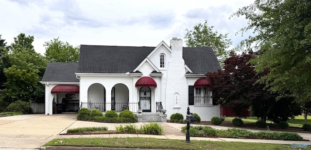 102 Jackson St, Albertville, AL 35950 - view of front of home with driveway, a chimney, a shingled roof, and a porch