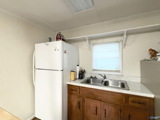 102 Jackson St, Albertville, AL 35950 - kitchen with freestanding refrigerator, a sink, brown cabinetry, and light countertops