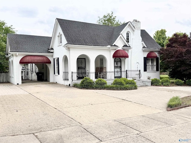 102 Jackson St, Albertville, AL 35950 - view of front of home with driveway, covered porch, a shingled roof, and a chimney