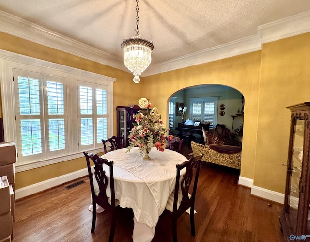 102 Jackson St, Albertville, AL 35950 - dining area featuring arched walkways, a chandelier, baseboards, plenty of natural light, and crown molding