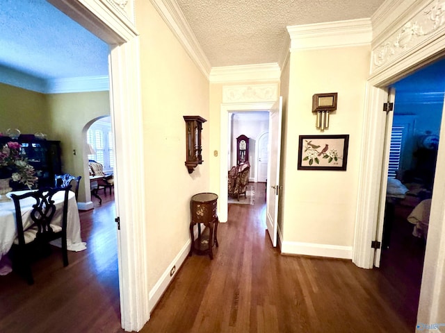 102 Jackson St, Albertville, AL 35950 - hallway with arched walkways, dark wood-style floors, a textured ceiling, baseboards, and crown molding