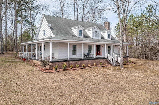 country-style home featuring a porch, a chimney, and roof with shingles