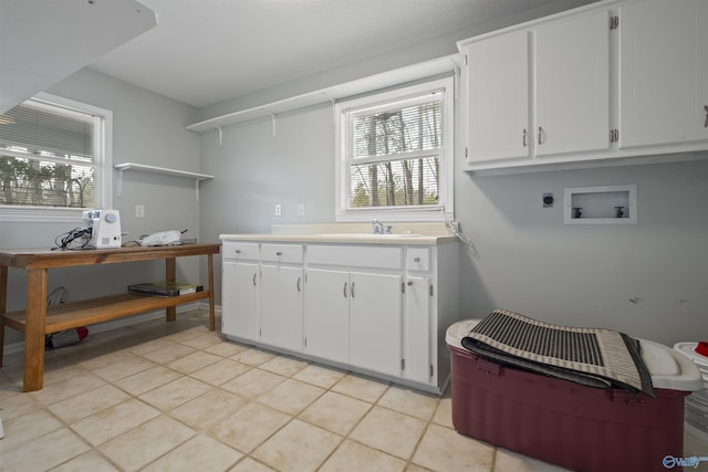 clothes washing area featuring cabinet space, hookup for an electric dryer, hookup for a washing machine, and plenty of natural light