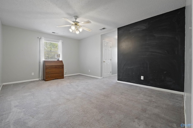 spare room featuring baseboards, visible vents, carpet floors, and ceiling fan