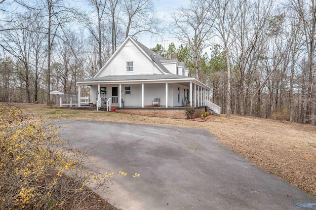 farmhouse with covered porch and a chimney