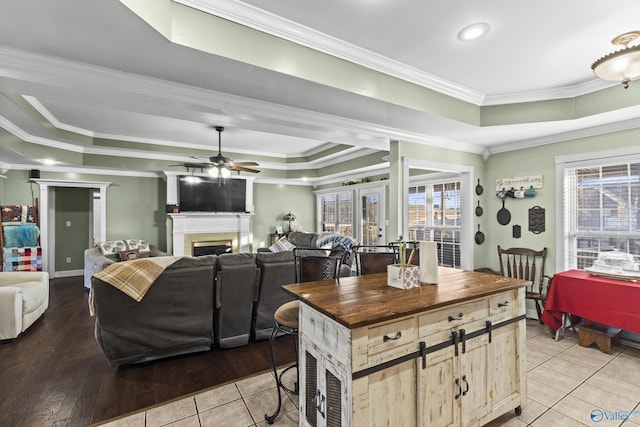 kitchen with light tile patterned floors, a tray ceiling, and ornamental molding