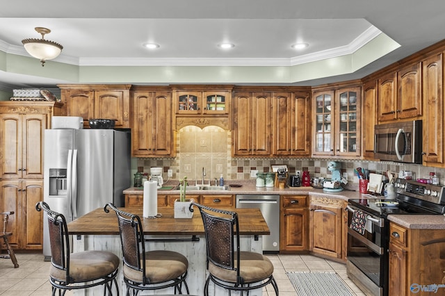 kitchen featuring crown molding, appliances with stainless steel finishes, sink, and light tile patterned floors