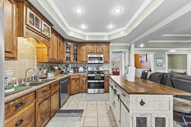 kitchen featuring sink, decorative backsplash, ornamental molding, light tile patterned floors, and stainless steel appliances