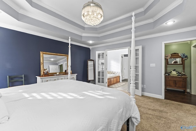 bedroom featuring ensuite bathroom, crown molding, light carpet, a tray ceiling, and a notable chandelier