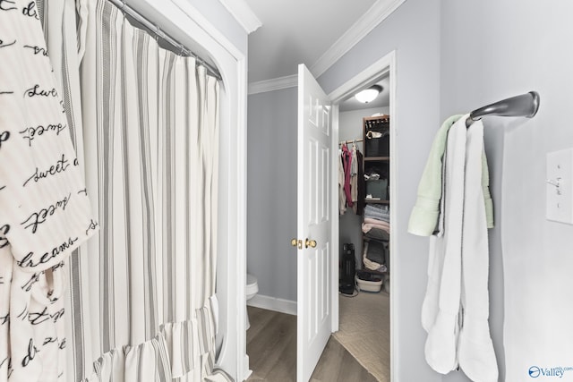 bathroom featuring crown molding, walk in shower, toilet, and hardwood / wood-style flooring