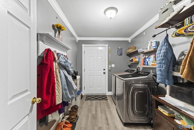 washroom featuring ornamental molding, separate washer and dryer, and light hardwood / wood-style flooring