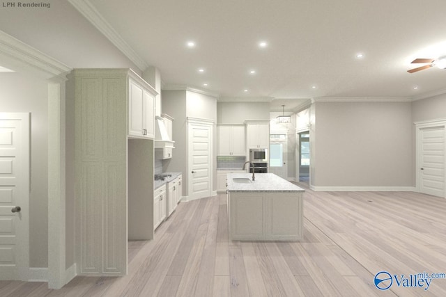 kitchen with ornamental molding, light hardwood / wood-style flooring, white cabinetry, stainless steel microwave, and an island with sink