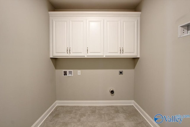 washroom with hookup for an electric dryer, light tile patterned flooring, cabinets, and hookup for a washing machine