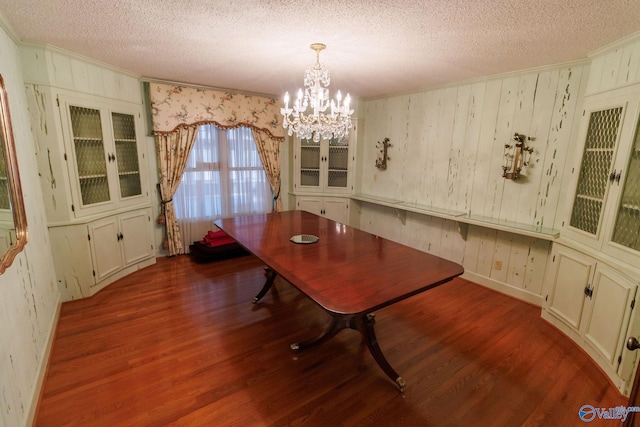 dining room with hardwood / wood-style floors, crown molding, and a textured ceiling