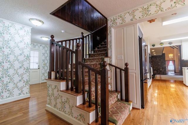 stairway featuring hardwood / wood-style floors and a textured ceiling