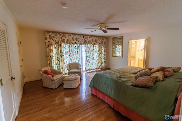 bedroom with hardwood / wood-style flooring, ceiling fan, connected bathroom, and a textured ceiling