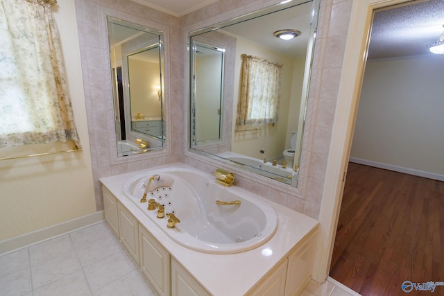 bathroom with toilet, crown molding, a textured ceiling, tile patterned flooring, and a washtub