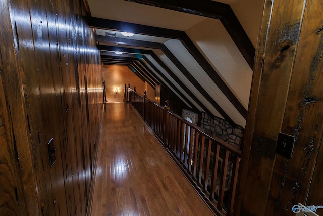 hallway with vaulted ceiling and wood-type flooring