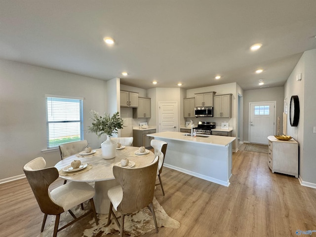 dining area with light wood-style flooring, recessed lighting, baseboards, and a wealth of natural light