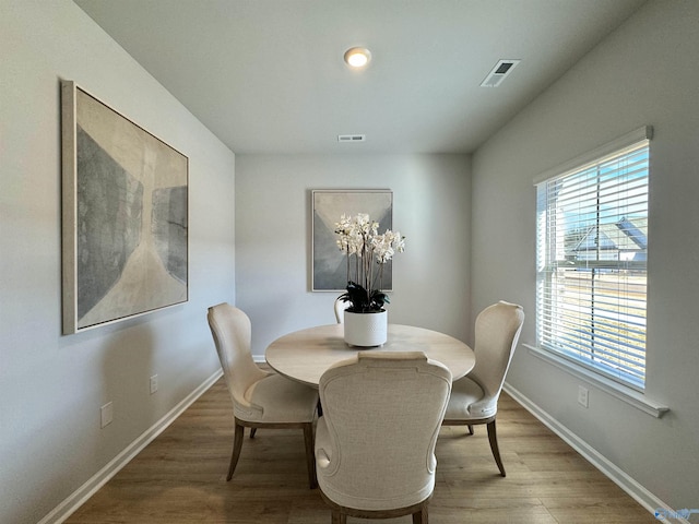 dining area featuring baseboards, light wood-style floors, and visible vents