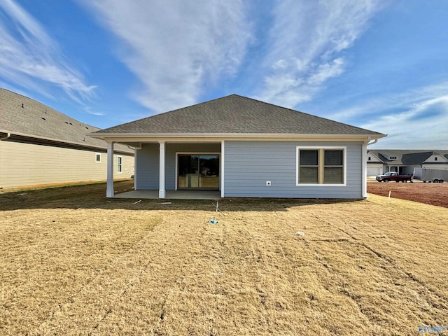 rear view of property featuring roof with shingles and a patio