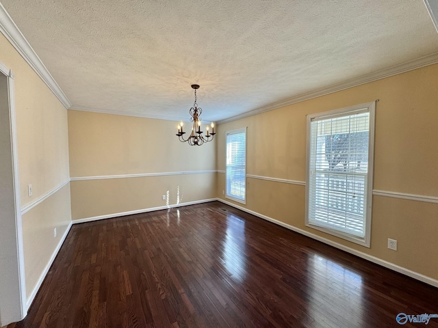 empty room featuring hardwood / wood-style flooring, a wealth of natural light, and a chandelier