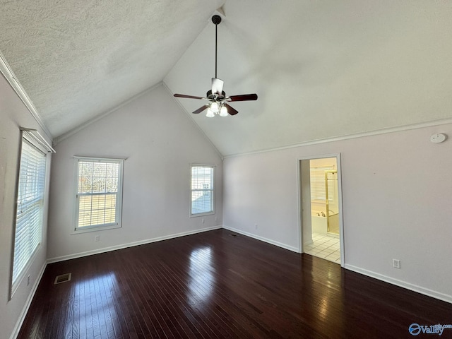 spare room featuring dark hardwood / wood-style flooring, ceiling fan, vaulted ceiling, and a textured ceiling