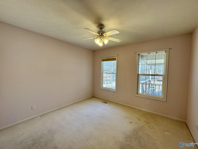 carpeted spare room with ceiling fan and a textured ceiling