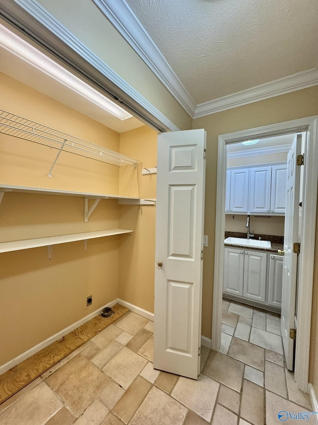 laundry room with crown molding, electric dryer hookup, sink, and a textured ceiling