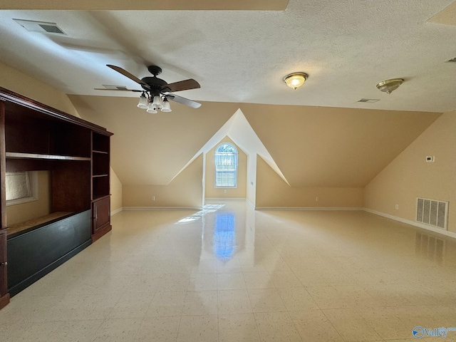 additional living space featuring vaulted ceiling, ceiling fan, and a textured ceiling