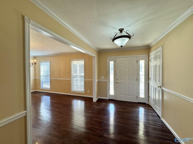 foyer featuring dark wood-type flooring, ornamental molding, and a textured ceiling