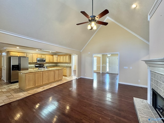 unfurnished living room with high vaulted ceiling, ornamental molding, ceiling fan, a fireplace, and hardwood / wood-style floors