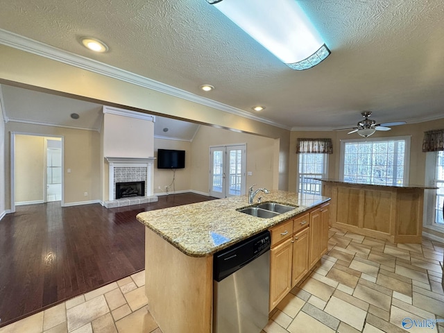 kitchen featuring french doors, stainless steel dishwasher, sink, and a center island with sink