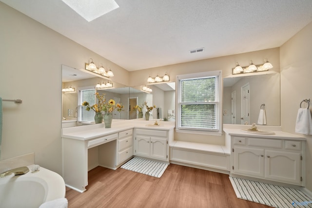 2010 Burlington Dr SE, Huntsville, AL 35803 - bathroom featuring wood finished floors, two vanities, and a bath