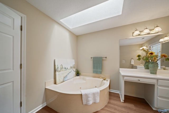 2010 Burlington Dr SE, Huntsville, AL 35803 - full bath with a skylight, a jetted tub, vanity, and wood finished floors