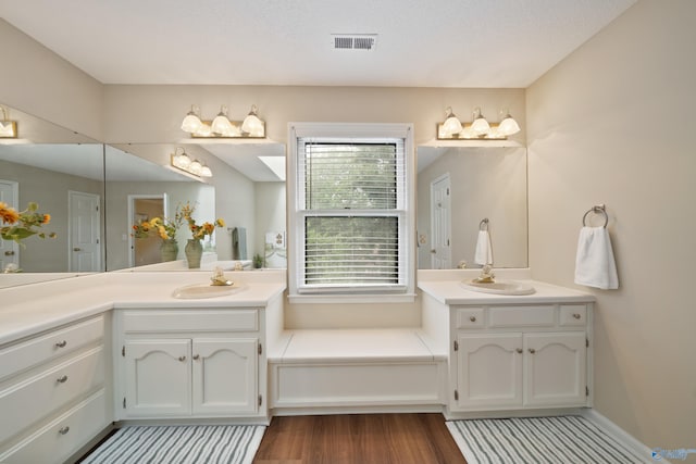2010 Burlington Dr SE, Huntsville, AL 35803 - full bathroom featuring two vanities, wood finished floors, and a garden tub