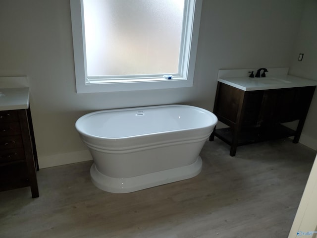 bathroom featuring vanity, a bathing tub, and hardwood / wood-style floors