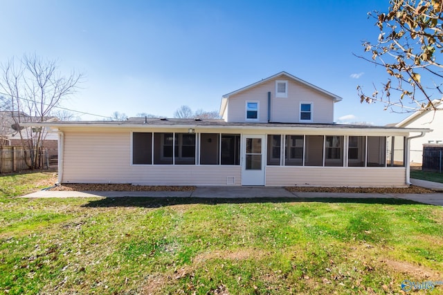 rear view of property featuring a lawn and a sunroom