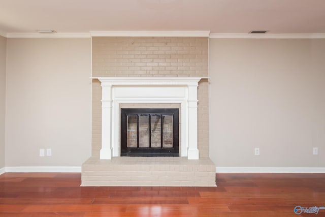 details featuring ornamental molding, hardwood / wood-style floors, and a brick fireplace