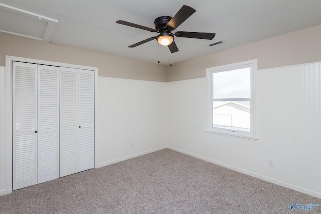 unfurnished bedroom with ceiling fan, light colored carpet, and a closet