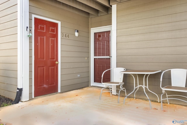 view of exterior entry with a patio area