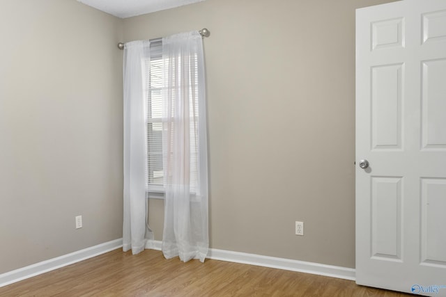 spare room featuring light wood-style flooring and baseboards