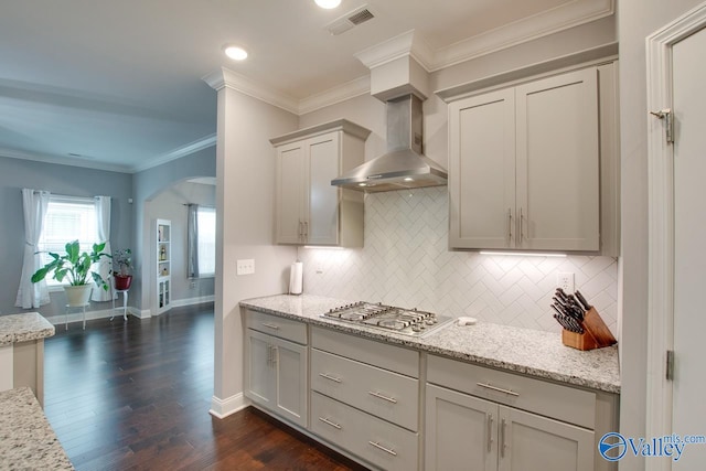 kitchen with dark hardwood / wood-style floors, stainless steel gas stovetop, backsplash, crown molding, and wall chimney range hood