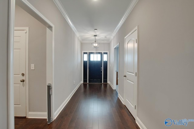 doorway to outside with a notable chandelier, dark hardwood / wood-style flooring, and crown molding