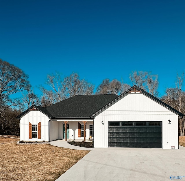 modern farmhouse featuring a front yard, a garage, and a porch