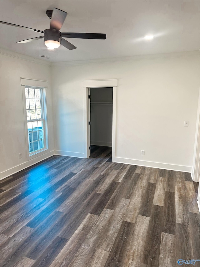 unfurnished room with ceiling fan, dark wood-type flooring, and crown molding